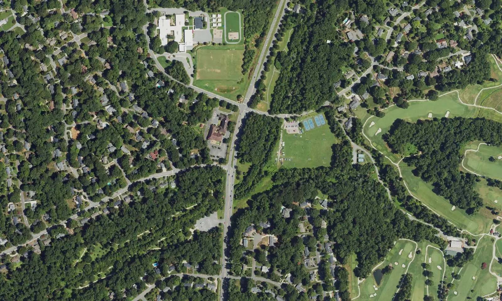 Aerial view of homes and wooded streets in the Sherwood Forest area of west Winston-Salem, with Sherwood Forest Elementary School at upper left